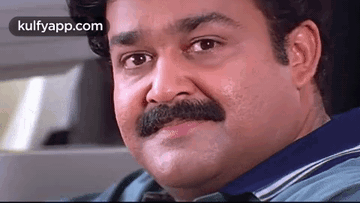 A Man With A Mustache Is Sitting In A Car . GIF