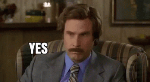 A Man With A Mustache Is Sitting In A Chair And Saying Yes . GIF