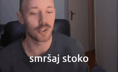 A Man With A Mustache Is Sitting In A Chair With A Cross In The Background And Says Smrtaj Stoko GIF