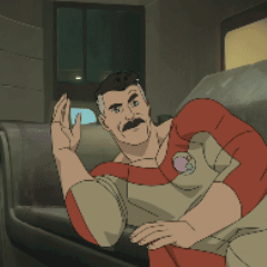 a man with a mustache is sitting on a couch and waving