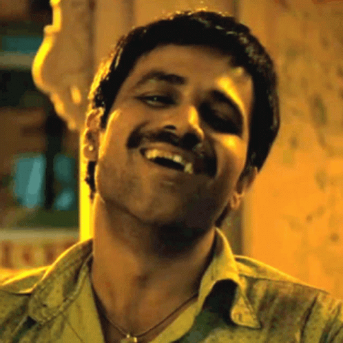 A Man With A Mustache Is Smiling And Making A Face . GIF