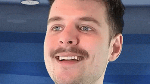 A Man With A Mustache Is Smiling With His Teeth Visible GIF