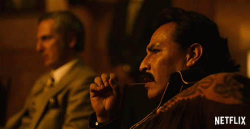 A Man With A Mustache Is Smoking A Cigar With A Netflix Logo In The Corner GIF