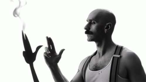 A Man With A Mustache Is Smoking A Cigarette GIF