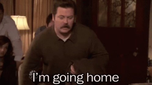 A Man With A Mustache Is Standing In A Living Room With The Words `` I 'M Going Home '' . GIF