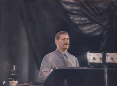 A Man With A Mustache Is Standing In Front Of A Podium . GIF