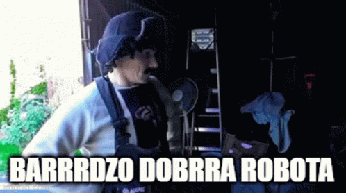 A Man With A Mustache Is Standing In Front Of A Sign That Says Barrrdz0 Dorra Robota GIF