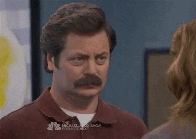 A Man With A Mustache Is Standing Next To A Woman And Looking At Her . GIF