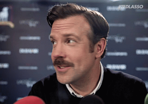 a man with a mustache is talking into a microphone with the hashtag #tedlasso on the bottom
