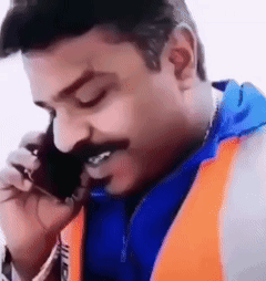 A Man With A Mustache Is Talking On A Cell Phone And Smiling . GIF