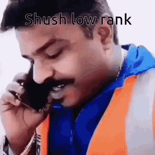 A Man With A Mustache Is Talking On A Cell Phone With The Caption Shush Low Rank . GIF