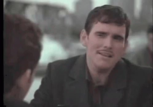 A Man With A Mustache Is Talking To Another Man In A Suit . GIF