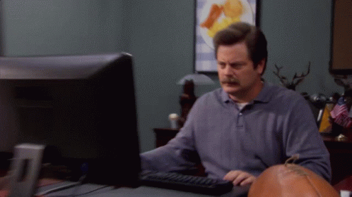 A Man With A Mustache Is Typing On A Keyboard In Front Of A Computer Monitor GIF