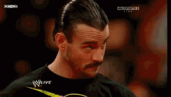 A Man With A Mustache Is Watching A Wrestling Match On Sky Sports Live GIF