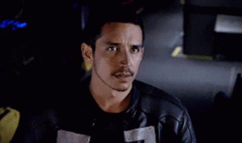A Man With A Mustache Is Wearing A Black Leather Jacket And A Black Shirt . GIF
