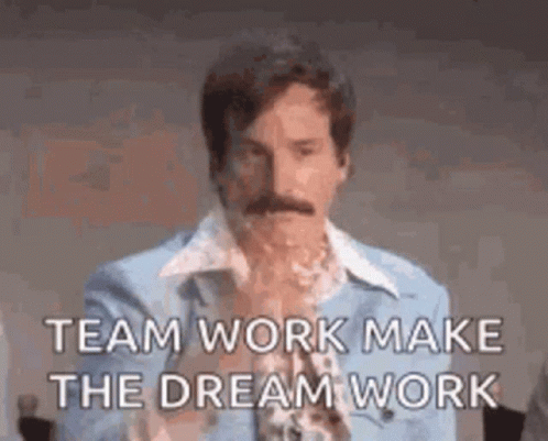 A Man With A Mustache Is Wearing A Blue Shirt And A Blue Jacket And Says `` Team Work Make The Dream Work '' . GIF