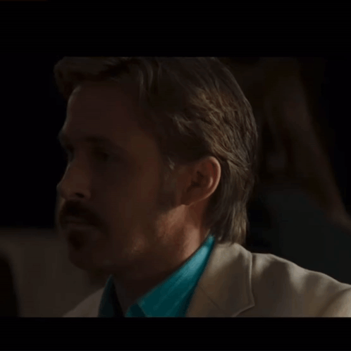 A Man With A Mustache Is Wearing A Blue Shirt And A White Suit GIF
