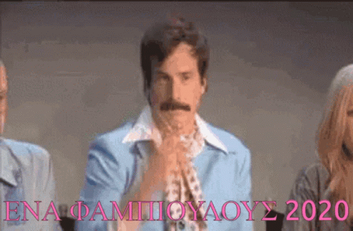 A Man With A Mustache Is Wearing A Blue Shirt With A White Collar And A Scarf Around His Neck . GIF