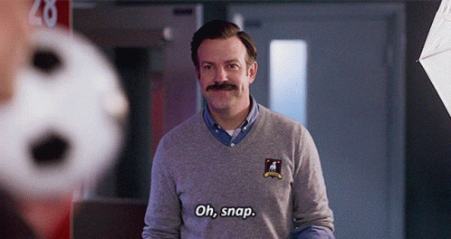 A Man With A Mustache Is Wearing A Grey Sweater And Says Oh Snap GIF