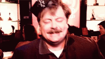 A Man With A Mustache Is Wearing A Party Hat And Making A Funny Face GIF