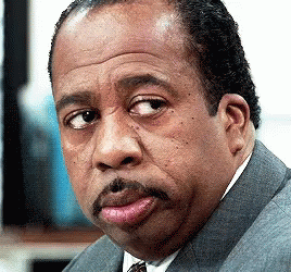 A Man With A Mustache Is Wearing A Suit And Tie And Making A Funny Face GIF