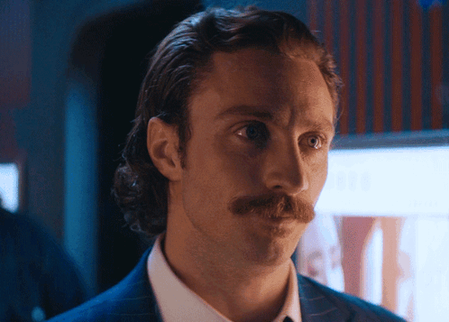 A Man With A Mustache Is Wearing A Suit And White Shirt GIF