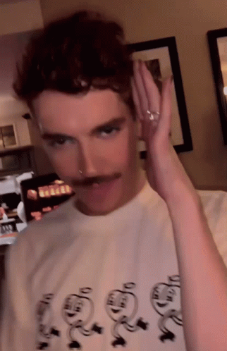 A Man With A Mustache Is Wearing A T-Shirt That Says ' Snoopy ' On The Front GIF