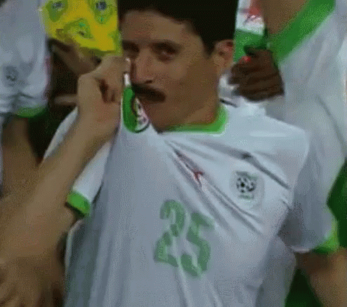 A Man With A Mustache Is Wearing A White And Green Jersey With The Number 25 On It GIF