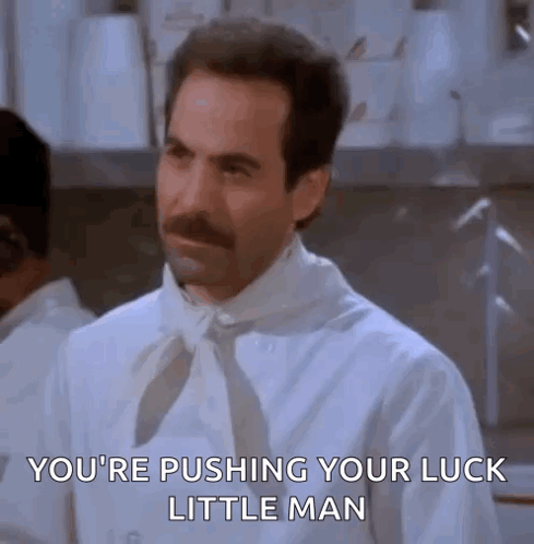 A Man With A Mustache Is Wearing A White Shirt And Tie And Is Pushing His Luck Little Man . GIF