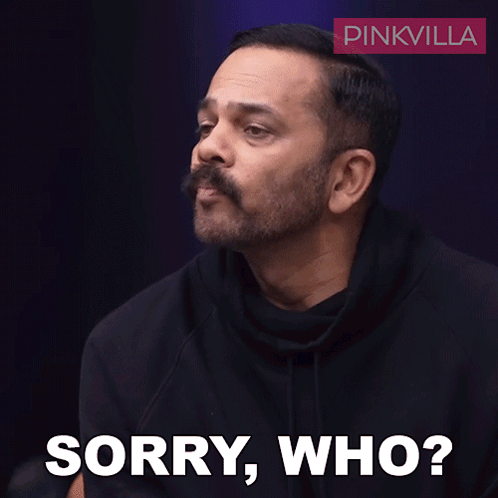 A Man With A Mustache Says Sorry Who In Front Of A Pinkvilla Logo GIF