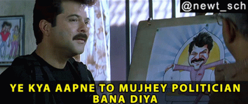 A Man With A Mustache Talks To Another Man In Front Of A Cartoon Of A Man With A Mustache GIF