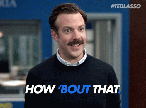 A Man With A Mustache Wearing A Black Sweater With The Words How Bout That On It GIF