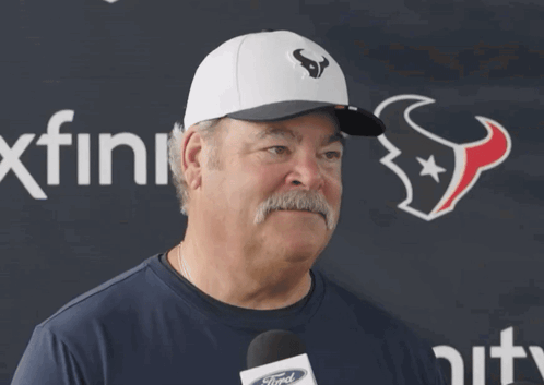 A Man With A Mustache Wearing A Hat With A Bull On It GIF