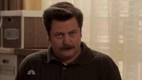 A Man With A Mustache Wears A Nbc Logo On His Shirt GIF
