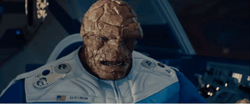 A Man With A Name Tag That Says Grimm Looks At The Camera GIF