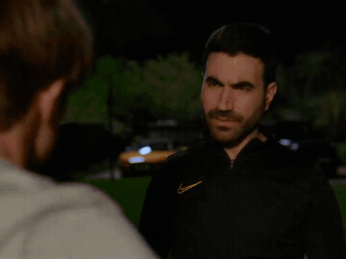 A Man With A Nike Logo On His Jacket Is Looking At Another Man GIF