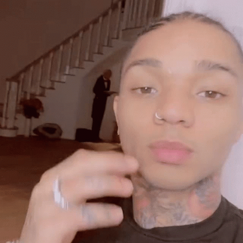 A Man With A Nose Ring And A Tattoo On His Neck Is Taking A Selfie . GIF