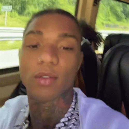A Man With A Nose Ring Is Sitting In A Car Looking At The Camera GIF