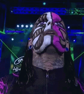 a man with a pink mask on his face is looking at the camera