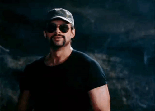 A Man With A Ponytail Wearing Sunglasses And A Hat GIF