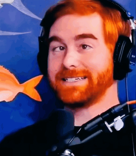 A Man With A Red Beard Is Wearing Headphones And Smiling . GIF