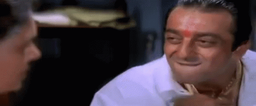 A Man With A Red Dot On His Forehead Is Smiling While Talking To Another Man . GIF