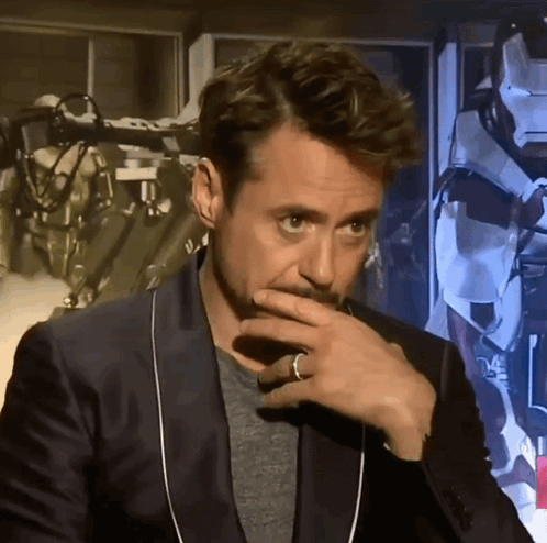 A Man With A Ring On His Finger Is Covering His Mouth With His Hand GIF