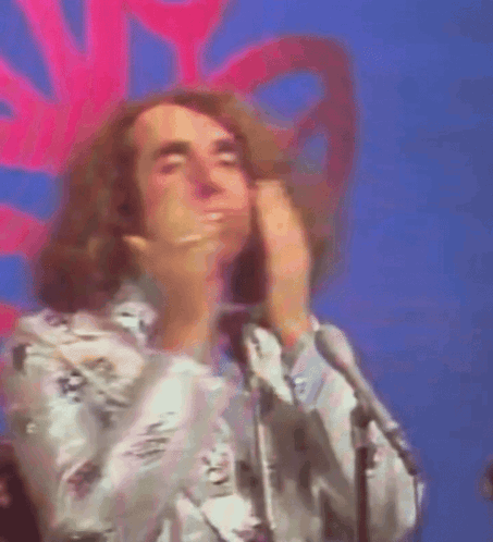 a man with a ring on his finger is covering his mouth with his hands