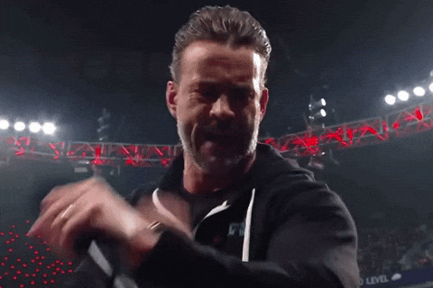 A Man With A Ring On His Finger Is Holding A Microphone And Making A Funny Face GIF