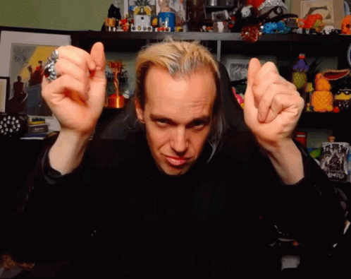 A Man With A Ring On His Finger Is Making A Face With His Hands GIF