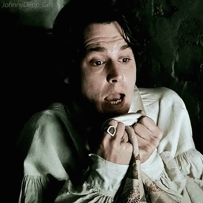A Man With A Ring On His Finger Is Making A Funny Face While Sitting In A Chair . GIF