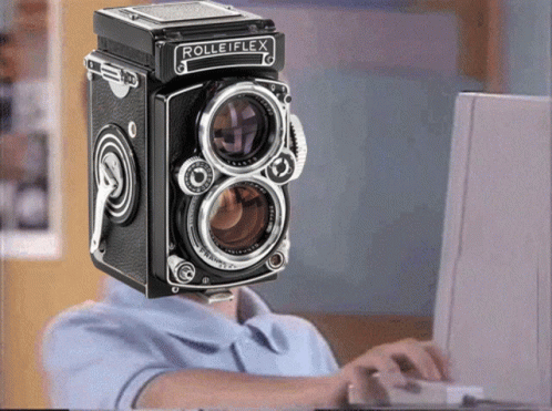 A Man With A Rolleiflex Camera On His Head GIF