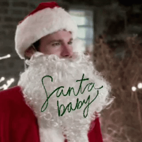 A Man With A Santa Hat And Beard Is Wearing A Santa Baby Shirt . GIF