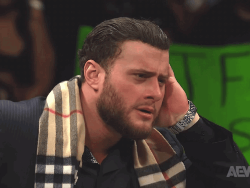 A Man With A Scarf Around His Neck Has A Watch On GIF